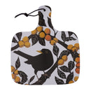 A square cutting board with a handle, featuring a printed design of a black bird perched on a branch with yellow-orange berries and dark leaves on a white background. A black hanging loop is attached to the top of the handle.