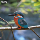 Colorful bird figurine on a branch with a blurred natural background