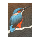 A completed jigsaw puzzle featuring a stylized blue and orange kingfisher perched on a branch against a brown and gray background, shown on a plain white backdrop.