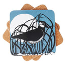 A stack of square coasters featuring a black-and-white lapwing perched among dark reeds against a muted blue background with a large white moon.