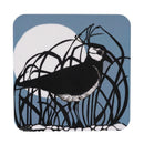 A square coaster featuring a black-and-white lapwing perched among dark reeds against a muted blue background with a large white moon.