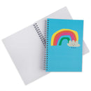 A spiral-bound notebook with a bright blue cover featuring a colorful rainbow and cloud illustration, shown with an open blank white page behind it on a white background.