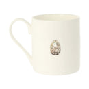 An off-white ceramic mug featuring a small, realistic speckled bird egg illustration on the front, set against a plain white background.