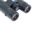 Close-up of a black binocular with a textured central focus wheel and two objective lenses, photographed on a clean white background. Visible text on the wheel reads 'Peregrine ED 10x42' 