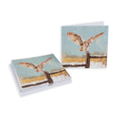 A stack of greeting cards and a single card displayed on a white background, both featuring a painted barn owl perched on a wooden fence against a pale blue sky and golden grasses.
