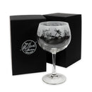 Glass with nature-themed engraving in front of a black box with 'The Milford Collection' logo.